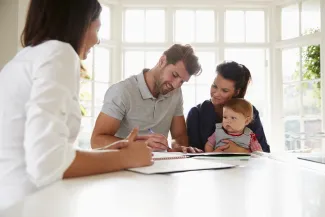 A family signing papers with a professional advisor